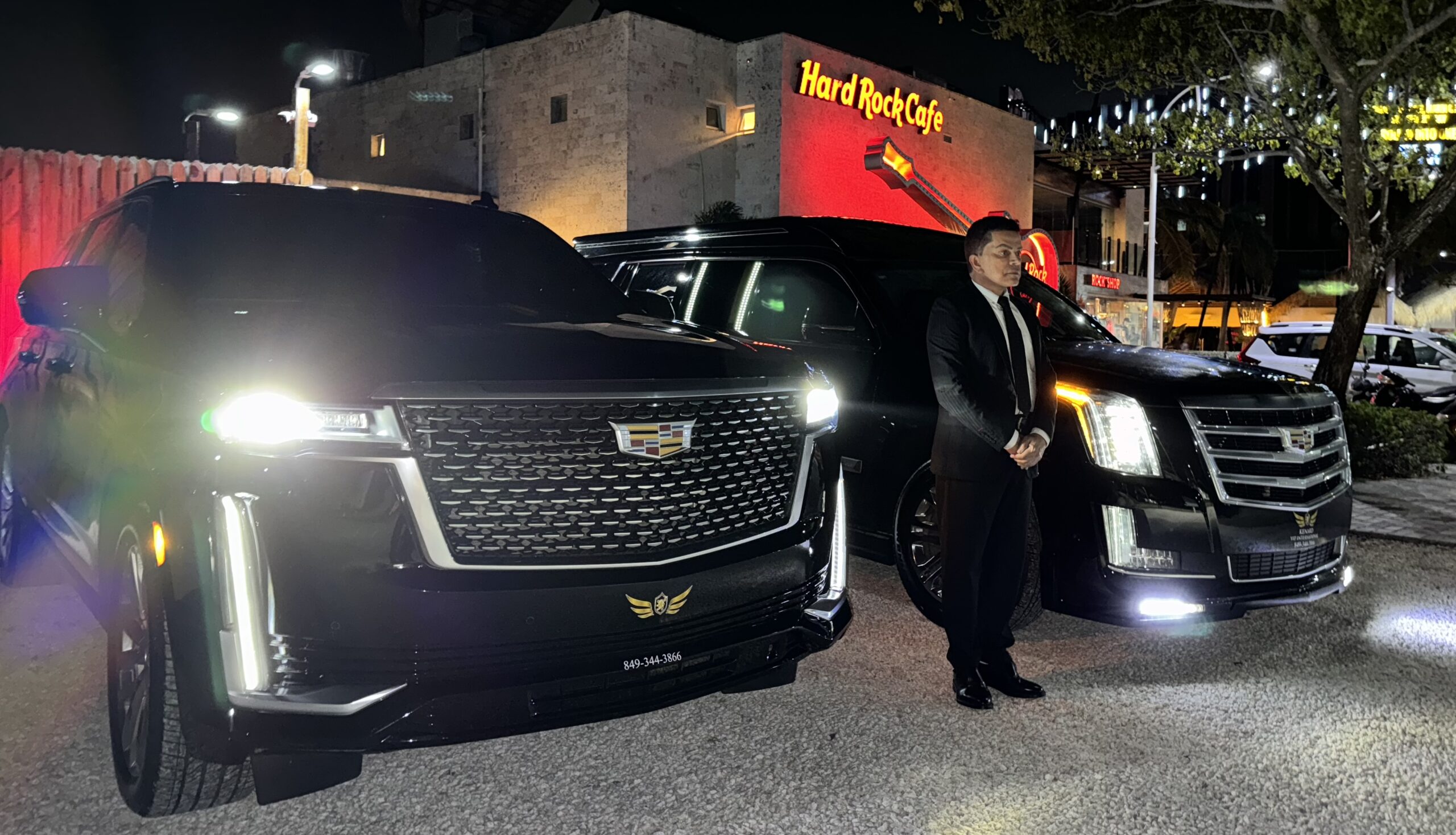 Black luxury SUV with blue underglow lighting during a night VIP transportation service